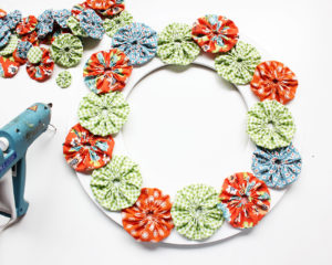 Glue Fabric Yo Yos to Wreath Form